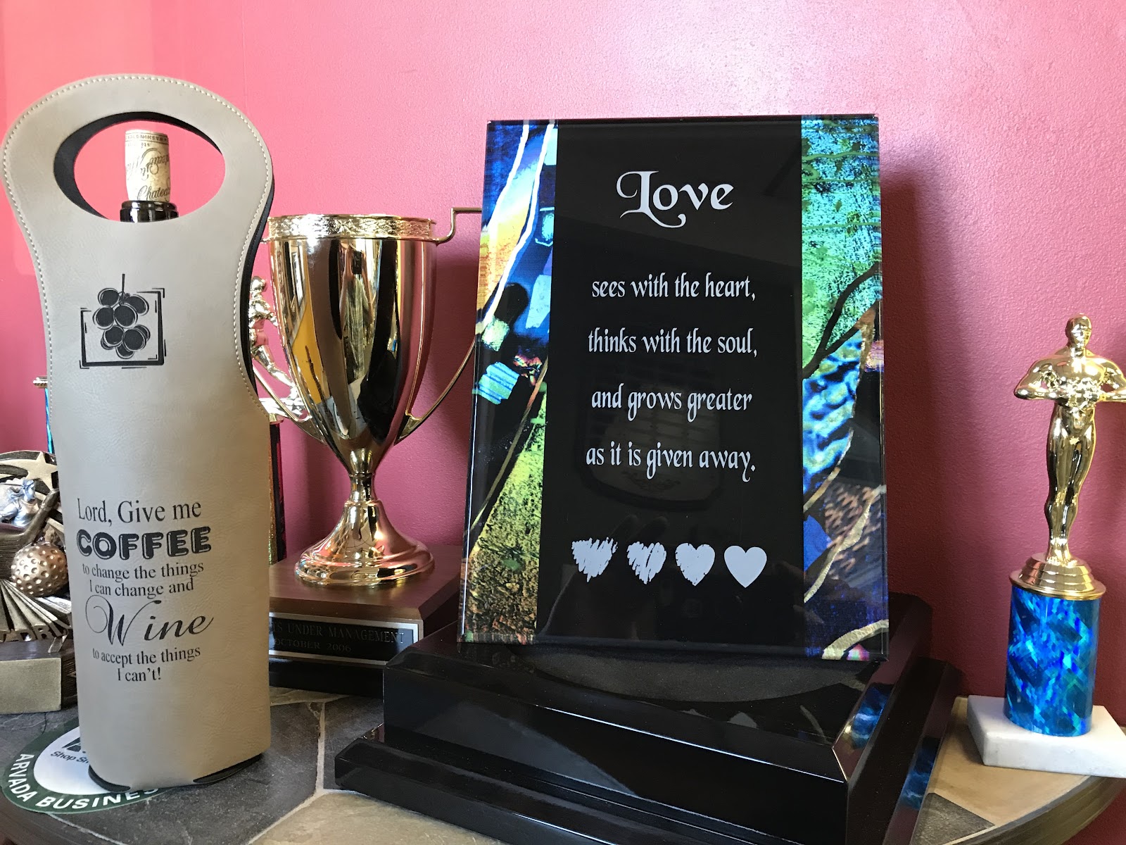 A colorful engraved gift, glass award, and blue trophy from Creative Trophy and Award Co