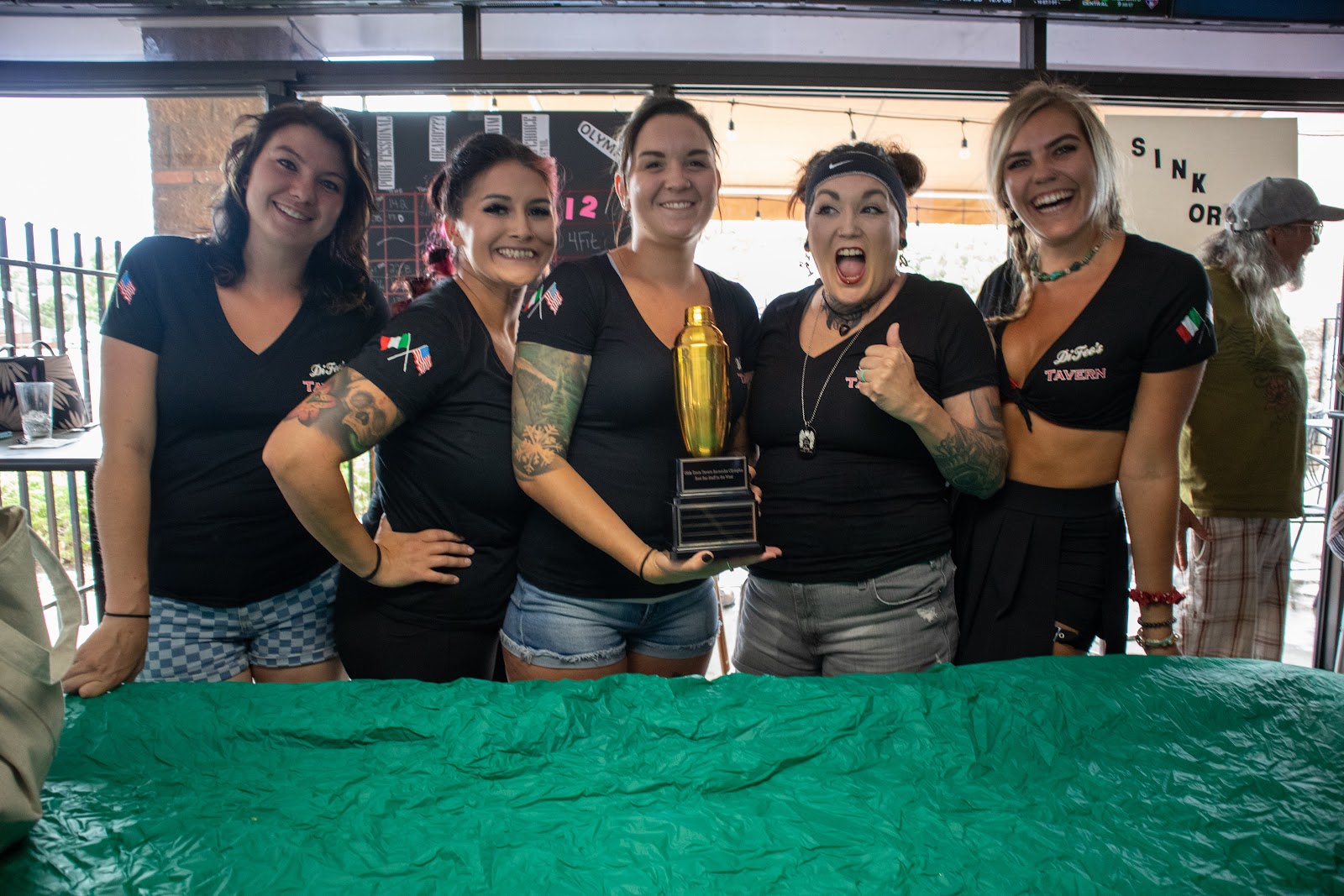 Customers from a bar team holding a custom engraved cocktail-shaker trophy from Creative Trophy and Award Co